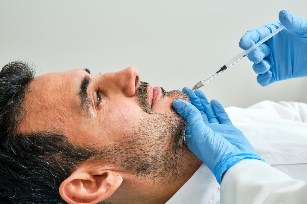 Chin injections being done on a male patient